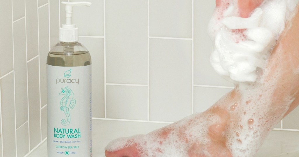 Puracy body wash in shower next to woman's soapyleg