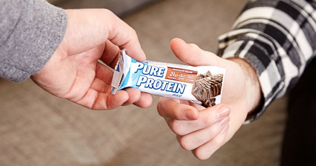 two people holding Pure Protein chocolate deluxe Bar