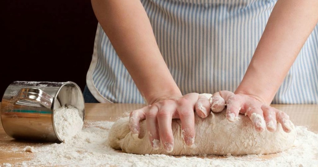 person kneading bread