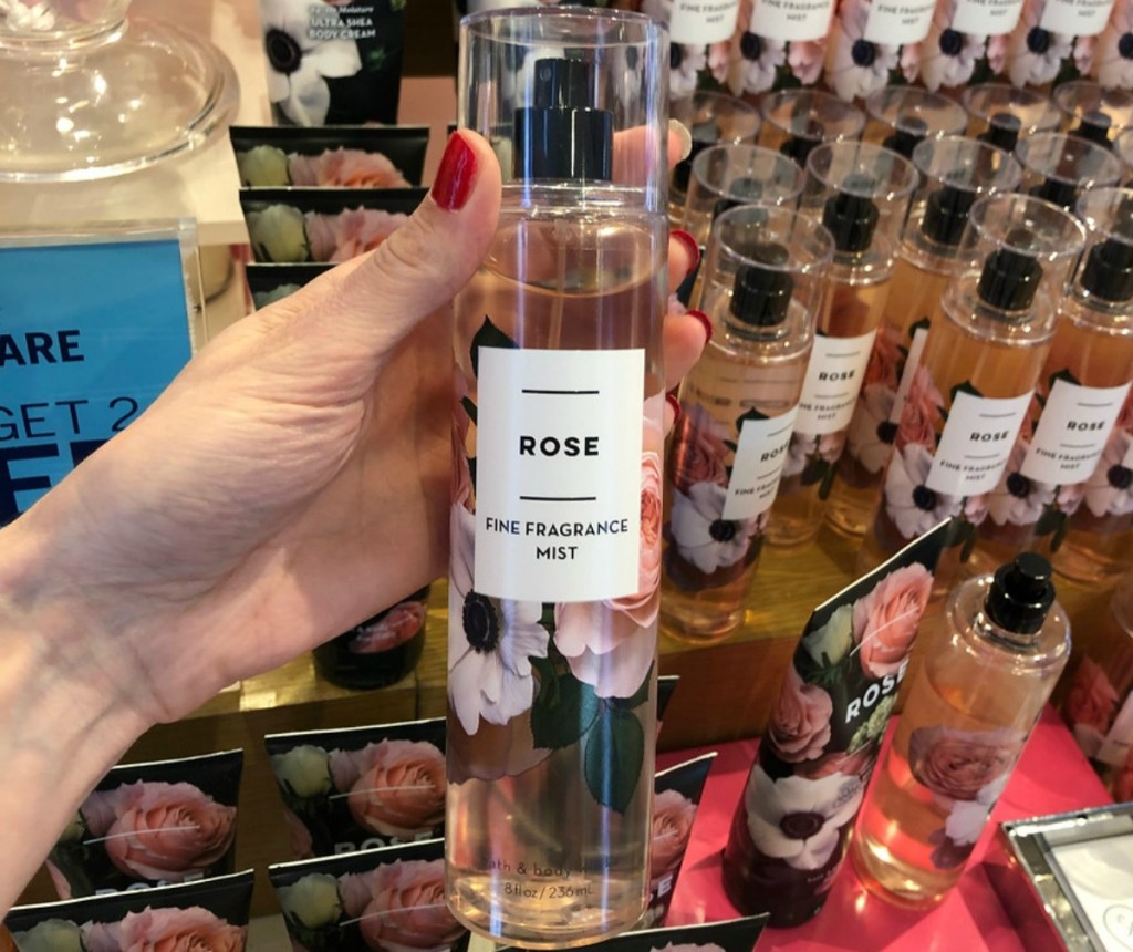 A bottle of Rose Fine Fragrance Mist from Bath and Body works New 2019 Line in-hand in front of store shelving