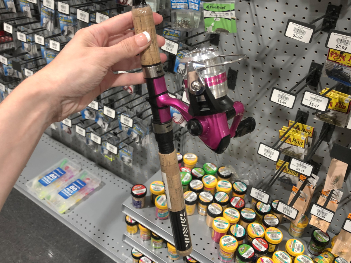woman holding a pink reel on a fishing rod in a store
