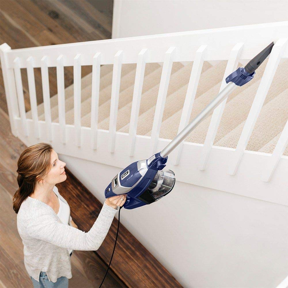 woman using a Shark Rocket Zero-m vacuum to clean the stairs