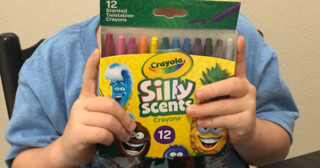child holding Crayola scented crayons