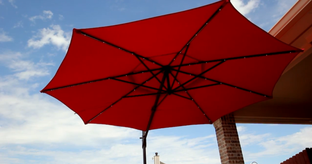 Simply Shade Offset Pre-lit 11-ft Patio Umbrella w/ Aluminum Frame & Base photo showing the lights and the sky in the background