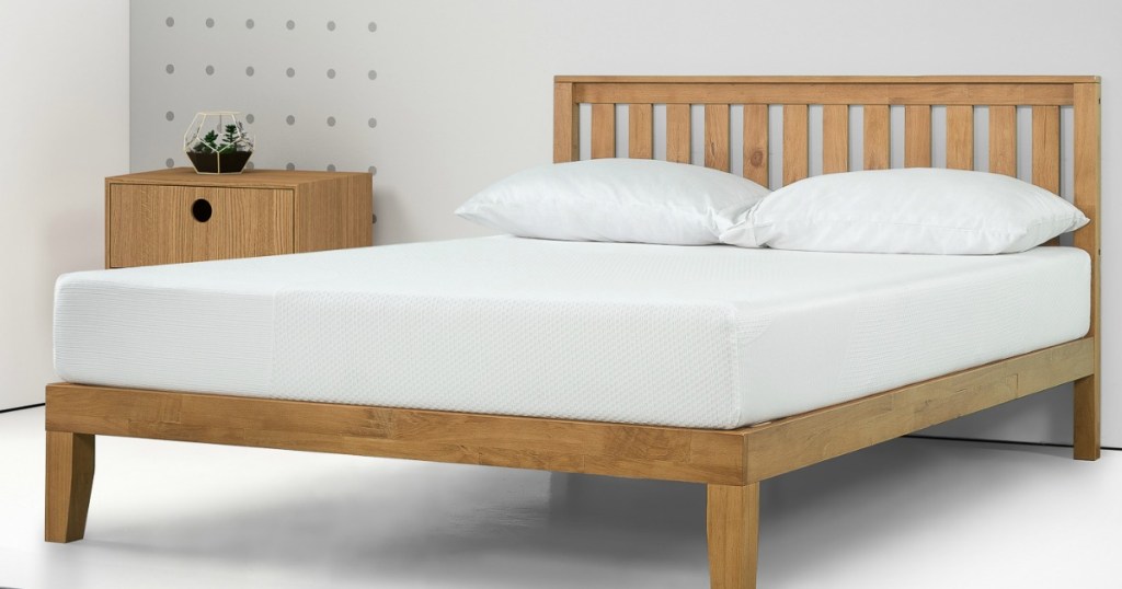 mattress on a wooden bed frame in a white room