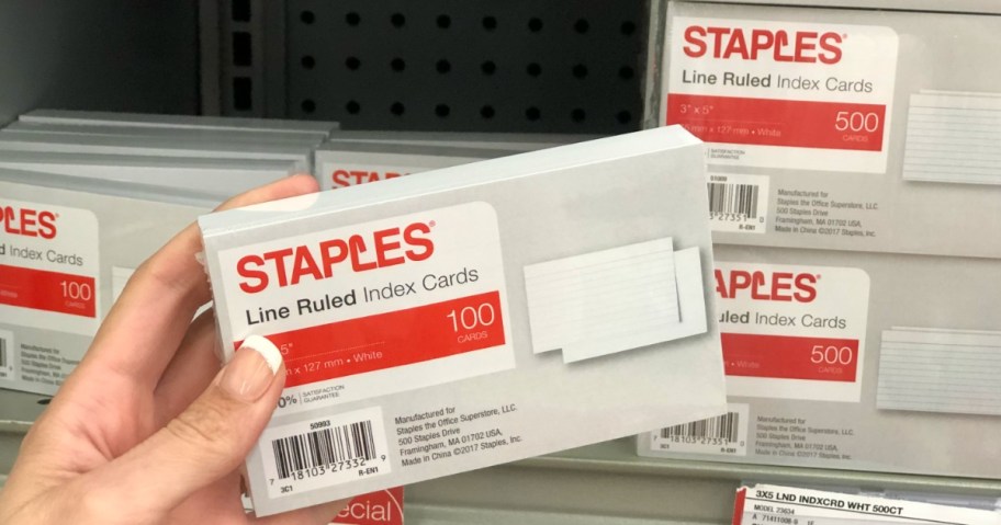 hand holding a pack of Staples white ruled index cards