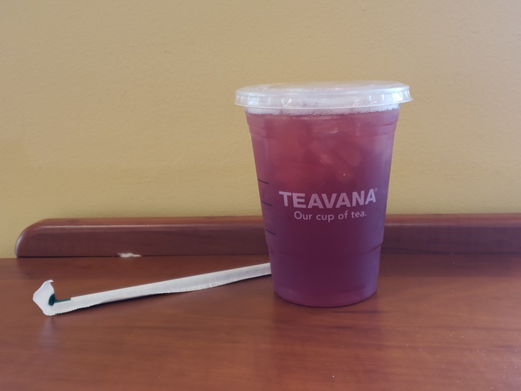 Iced Blueberry Black Tea Lemonade with straw on counter