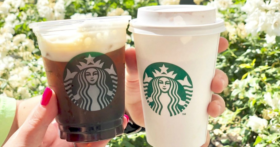 two people holding starbucks drinks