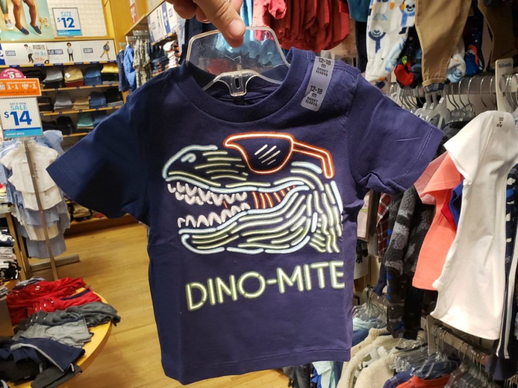Dino-mite Toddler Tee held up in store