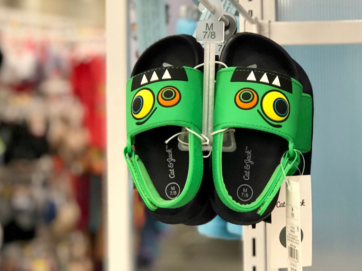Cute monster footbed sandals hanging on store peg