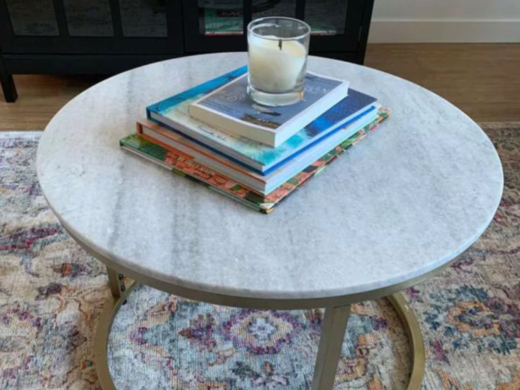 Threshold Dark Grey Marble Top Coffee Table with Gold Trim with books and candle on top in living room