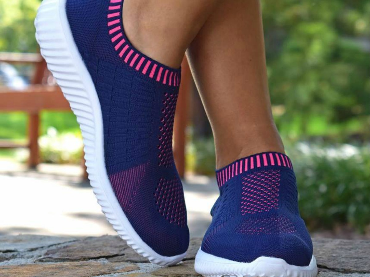 woman wearing Tiosebon Unisex Slip-on Walking Shoes in blue with pink accents
