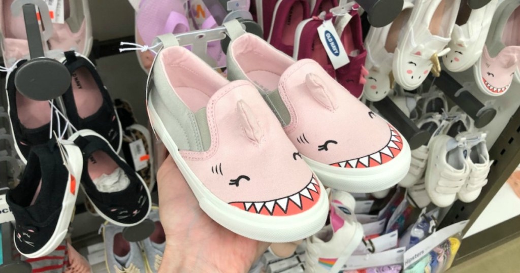 Someone holding up a pair of Toddler Shark Sneakers at Old Navy