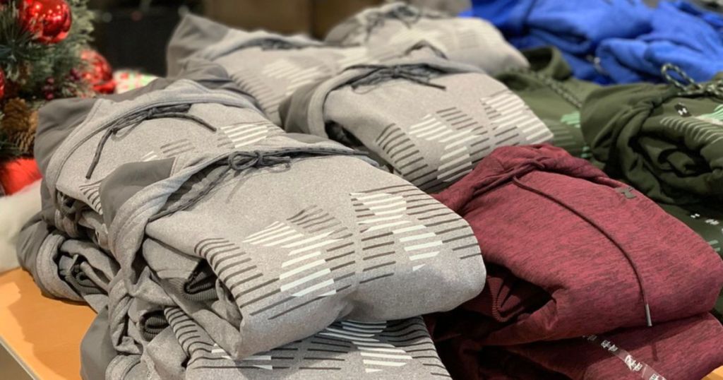 grey, maroon, and green under armour hoodies on table folded