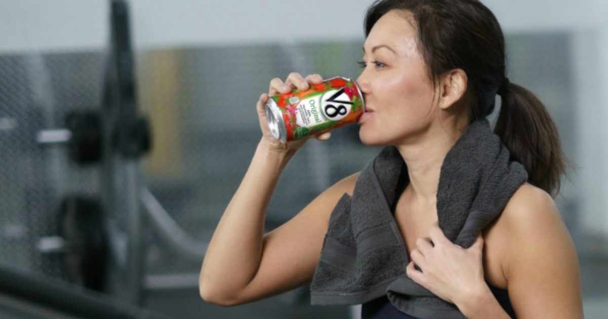 woman in workout clothes drinking a can ov V8 juice