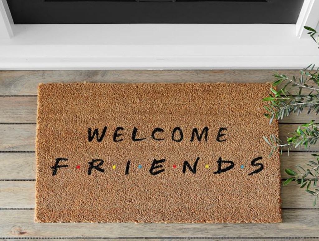 Friends welcome doormat in brown outside white doorway