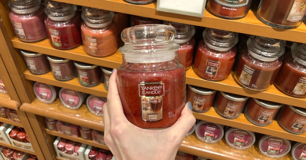 hand holding an apple cider Yankee Candle jar candle in store