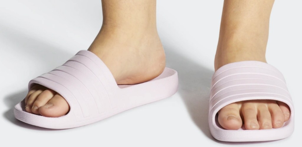 Woman wearing light pink adidas slide sandals