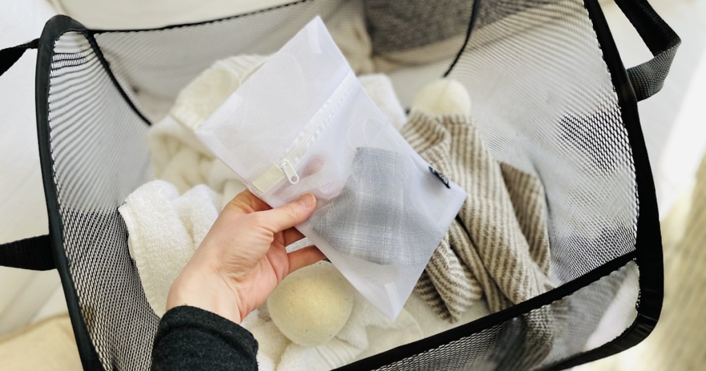 hand holding a laundry bag with masks inside