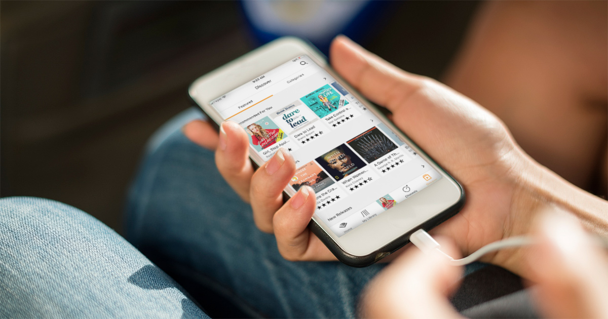 audible audiobooks displayed on iphone screen being held in hand