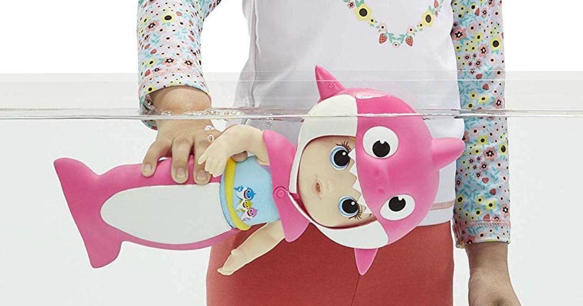 girl playing with a baby alive baby shark doll
