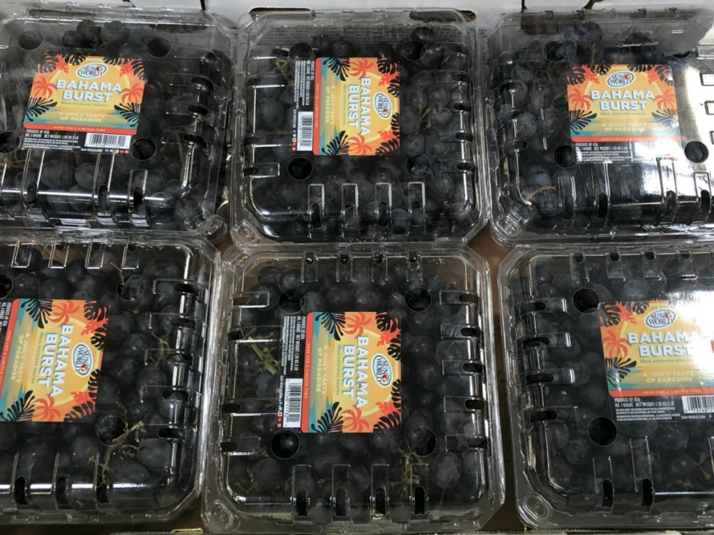 tray of packages of black grapes in store