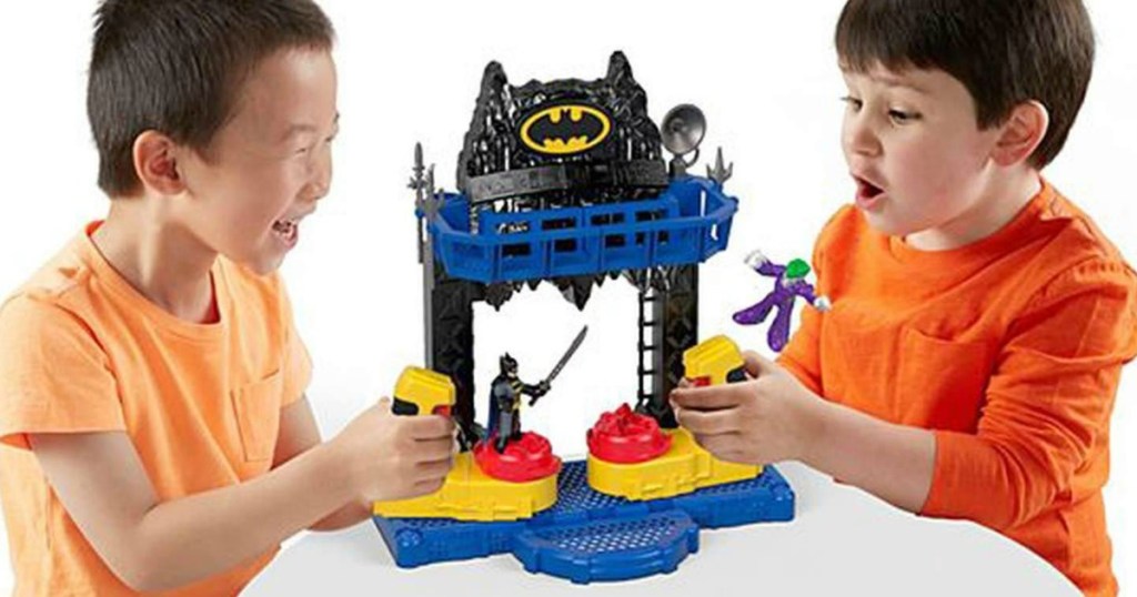 two little boys play with batman toy at table