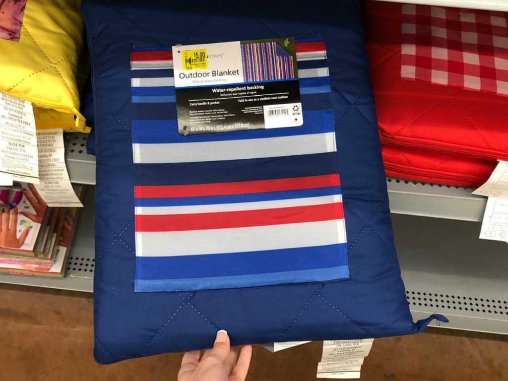 hand holding blue blanket by store shelf