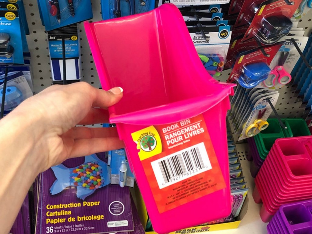 hand holding pink plastic bin in store