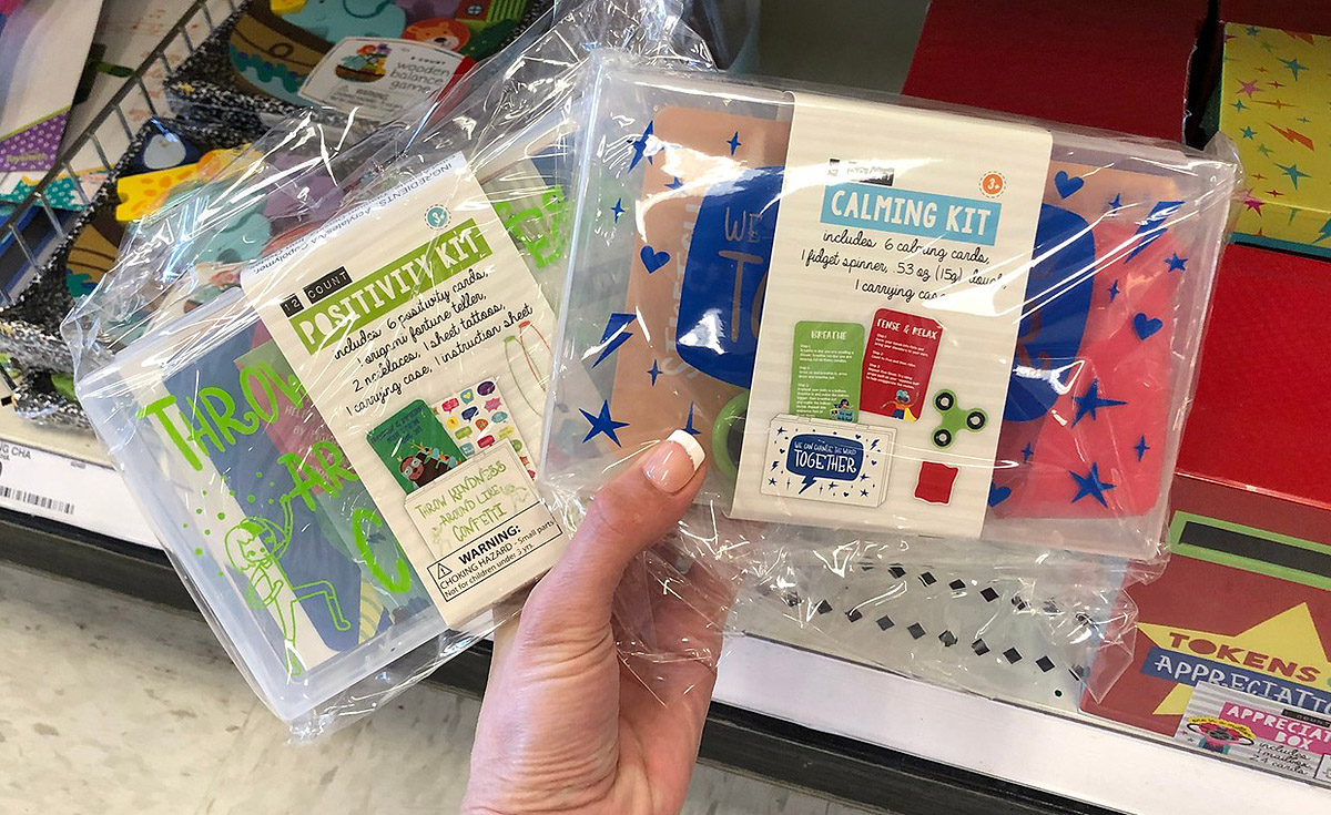positivity kit and calming kit being held in hand in front of a store shelf