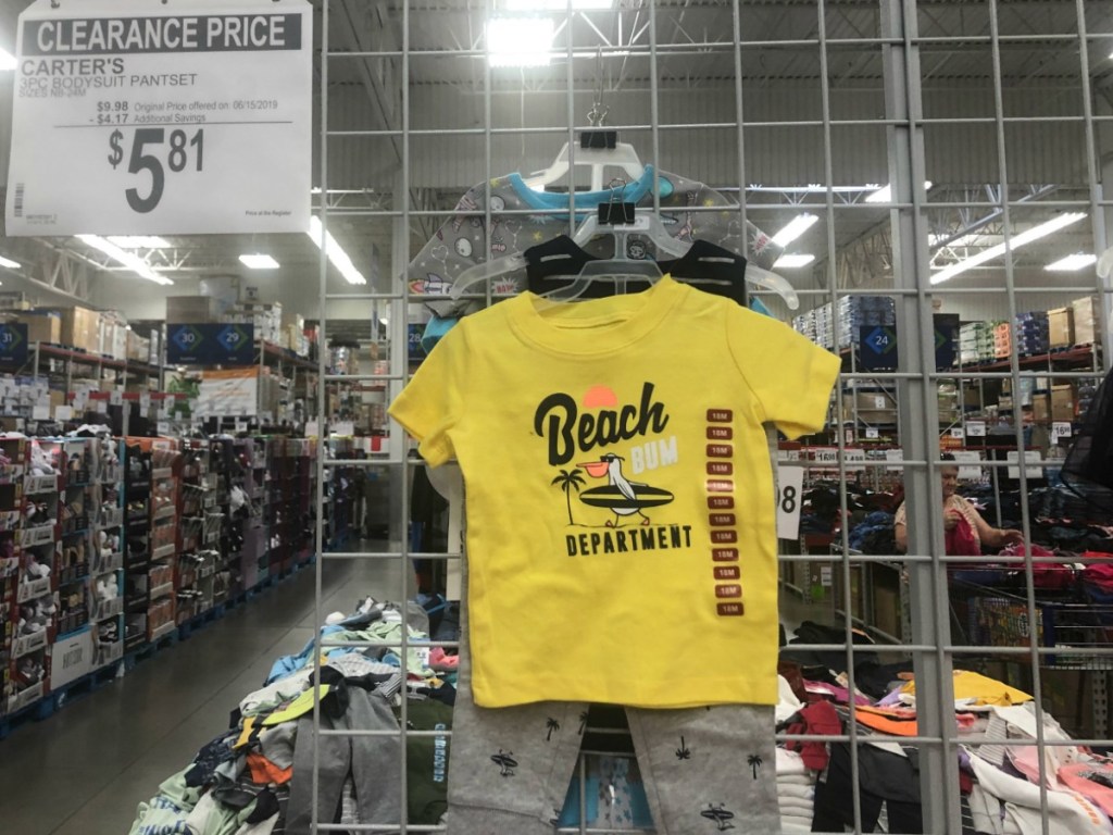 kids outfit hanging in store by sale sign
