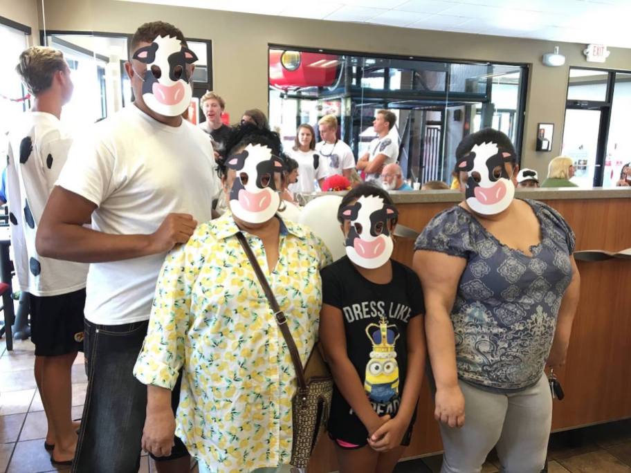 family dressed up with Chick-fil-A Cow Appreciation Day Face Mask