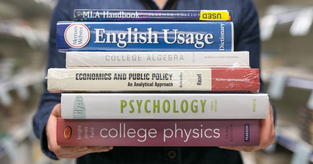 person holding a stack of free or cheap college textbooks