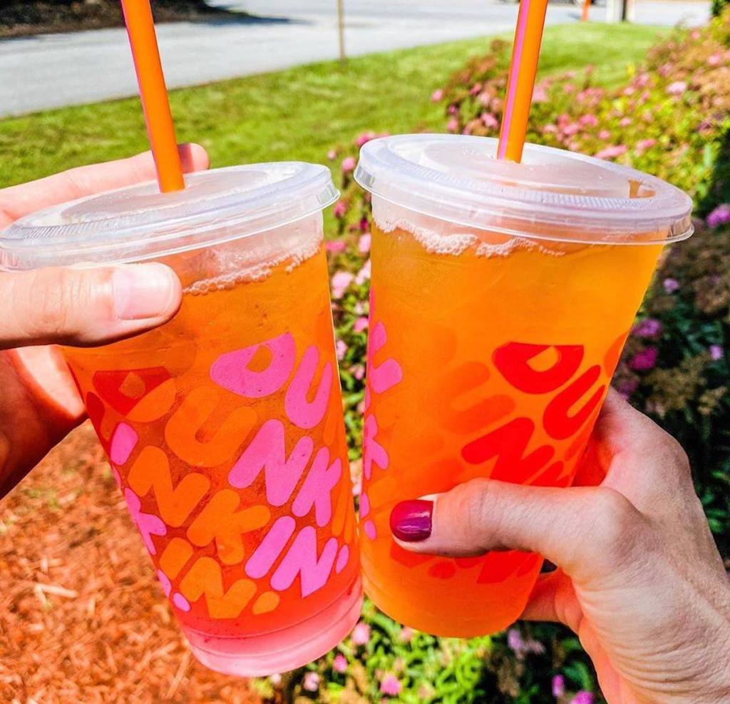 two people holding dunkin donuts refreshers drink