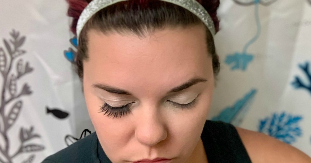 woman with eyes closed with fake eyelash extensions on one eye