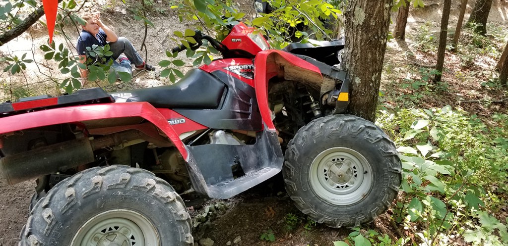 red four wheeler crashed into tree boy in woods