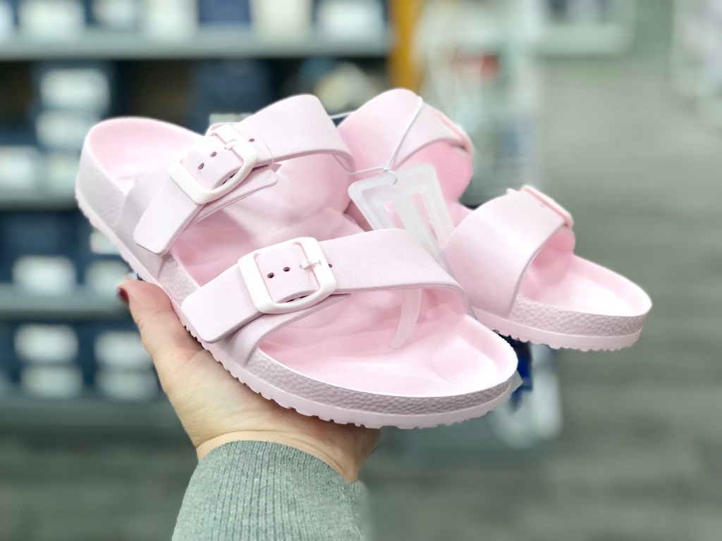 hand holding pink shoes in store