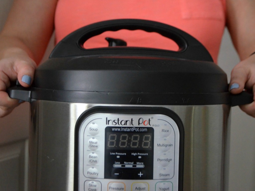 person holding pressure cooker with hands in front of them