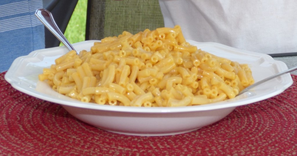 macaroni and cheese in a white bowl with 2 forks