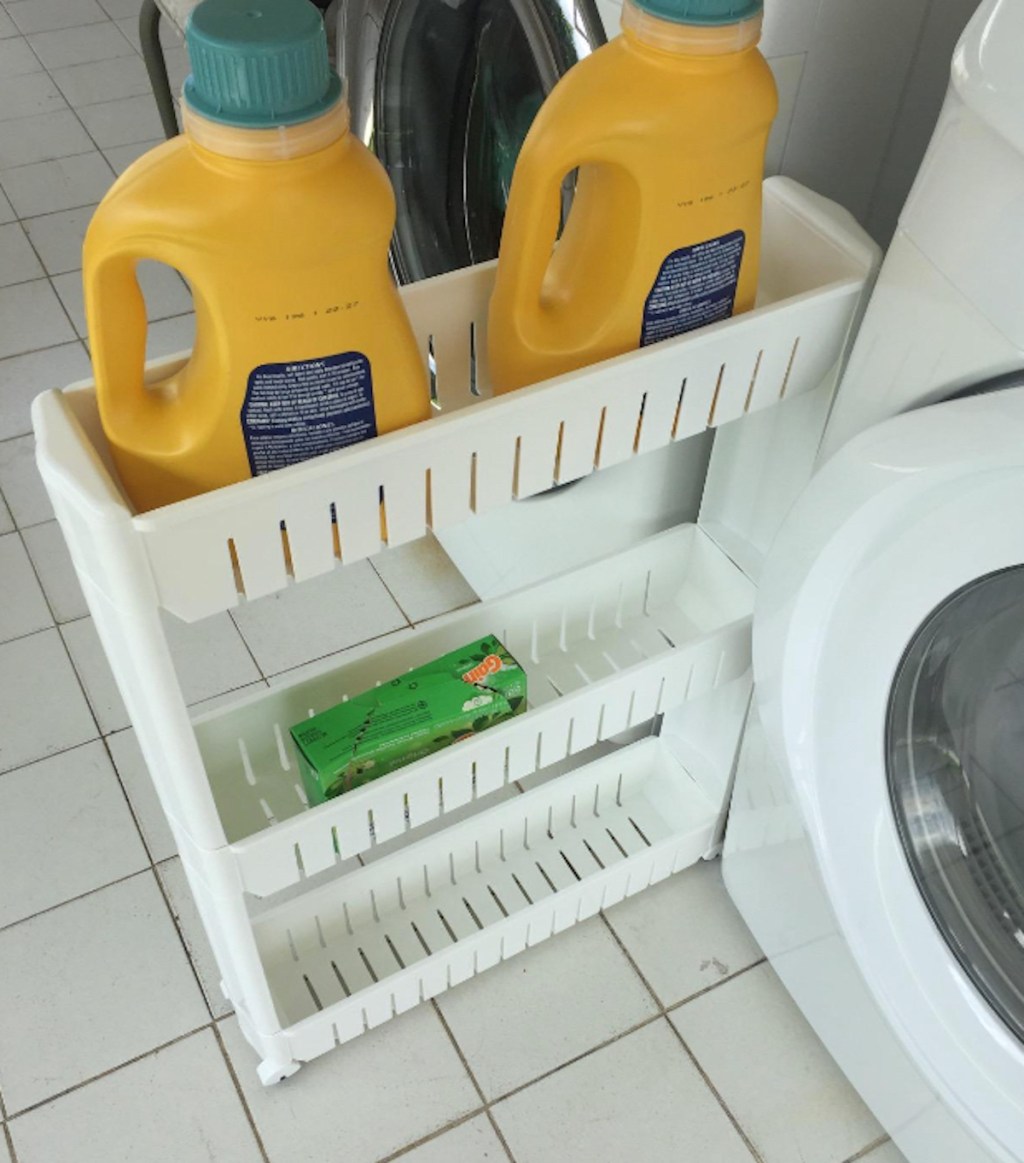 white rolling laundry cart with two yellow containers of detergent
