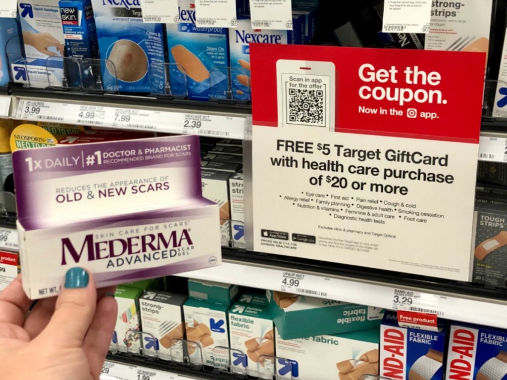 hand holding mederma product by store sign