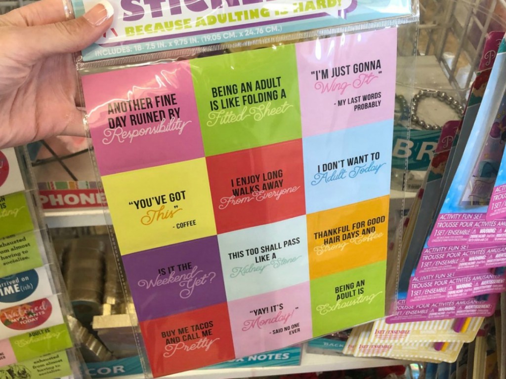 hand holding pack of colorful stickers by store display