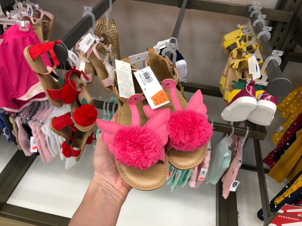 womans hand holding pink flamingo sandals in old navy