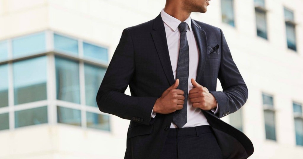 man modeling suit and tie outdoors with building
