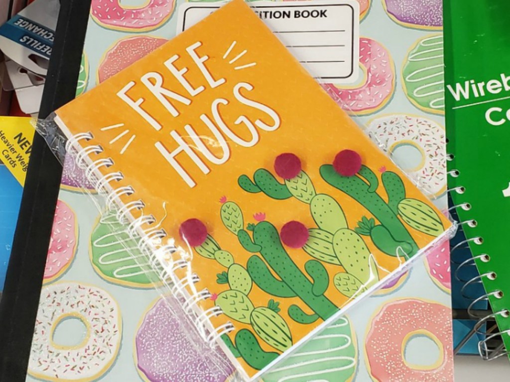 notebook with colors and pom pom decorations on it