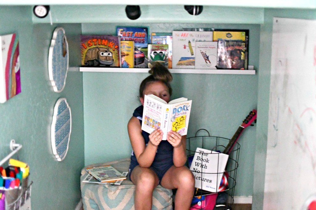 girl reading book in book nook 