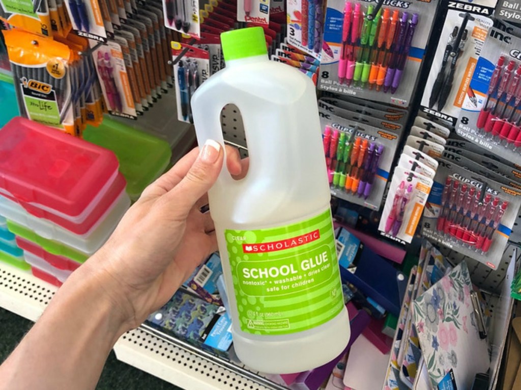 hand holding large jug of glue by store display