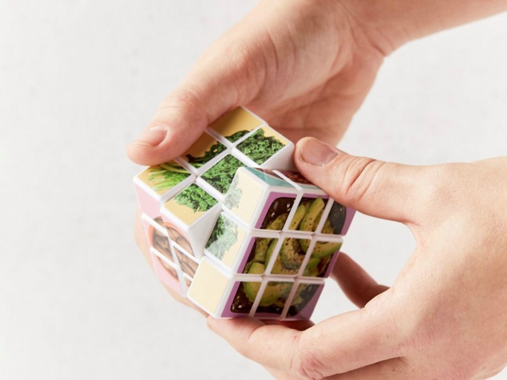 hands playing with rubik's cube labeled with food