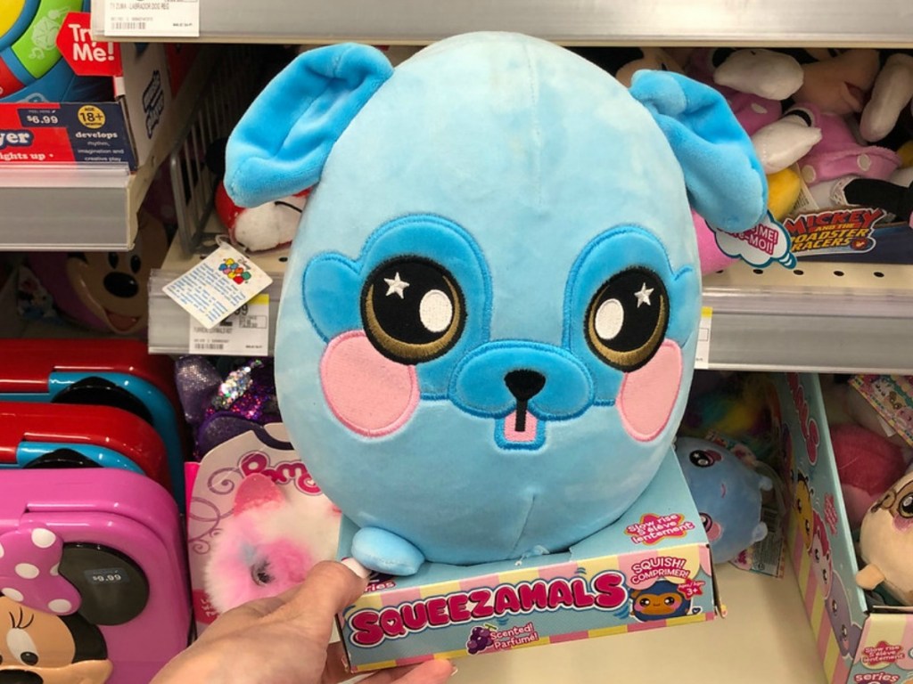 big blue plush toy held by hand near store display