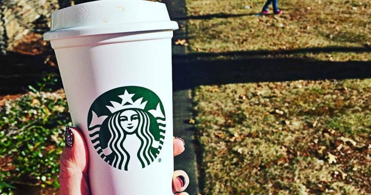 hand holding reusable starbucks cup outside